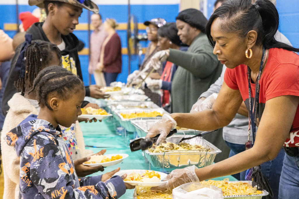 Woman serving Thanksgiving meals to children