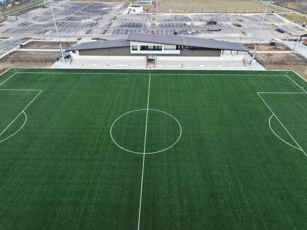 Kilbourne Run Sports Park Drone photo - image of turf field including bleachers and stadium structure.