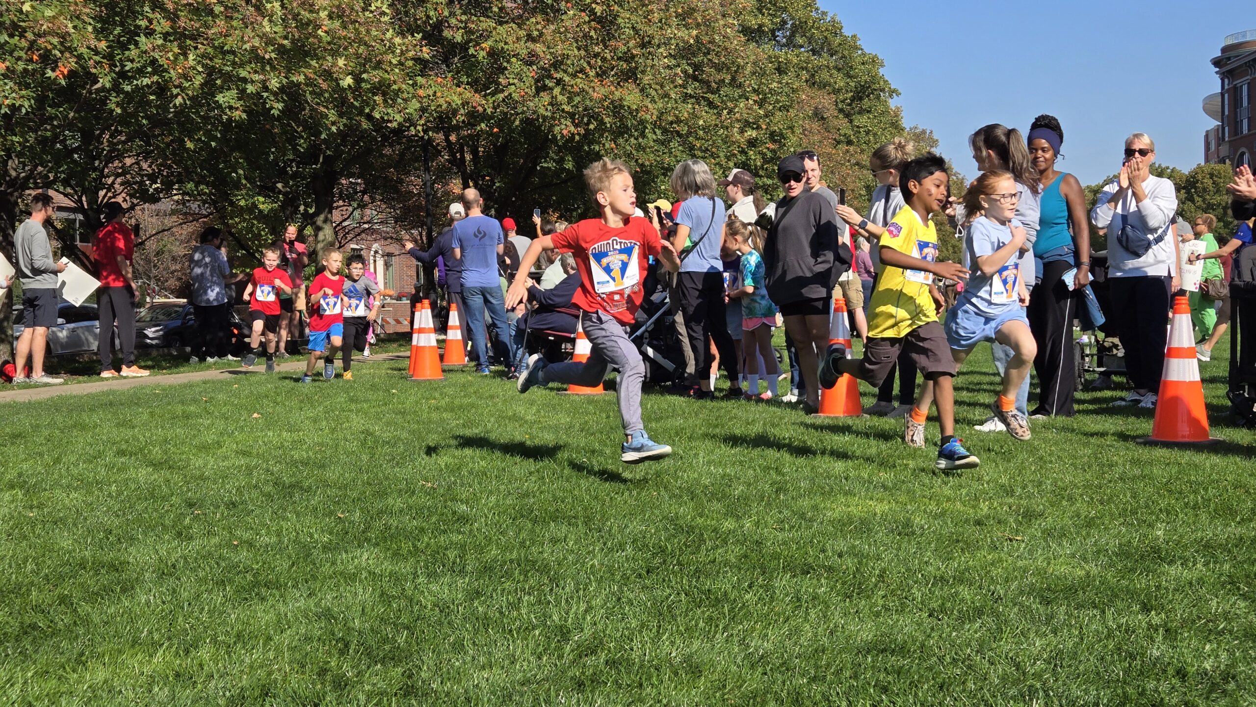 Group of children outside running in field.